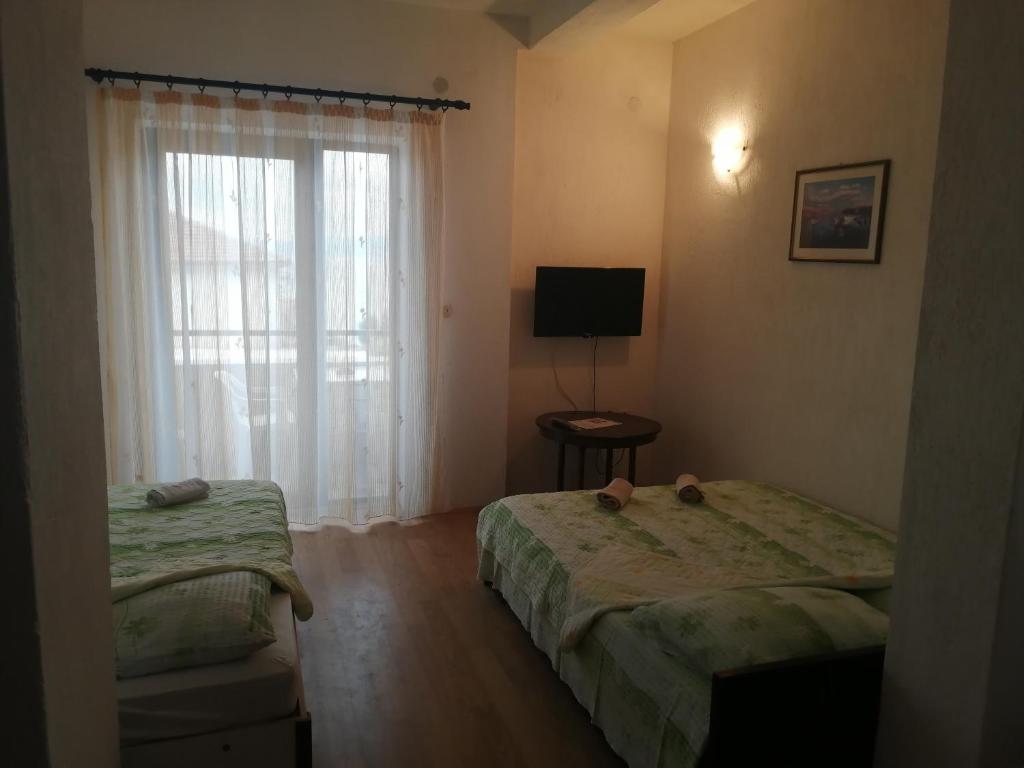 Habitación de hotel con 2 camas y ventana en Villa Geros, en Trpejca