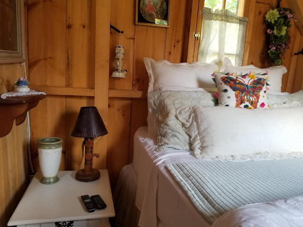 ein Schlafzimmer mit einem Bett und einem Tisch mit einer Lampe in der Unterkunft Four Ninety Muskoka B & B in Gravenhurst