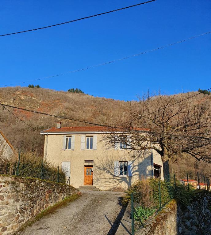 une maison sur un chemin de terre en face d'une colline dans l'établissement En pleine montagne, à Mercus-Garrabet