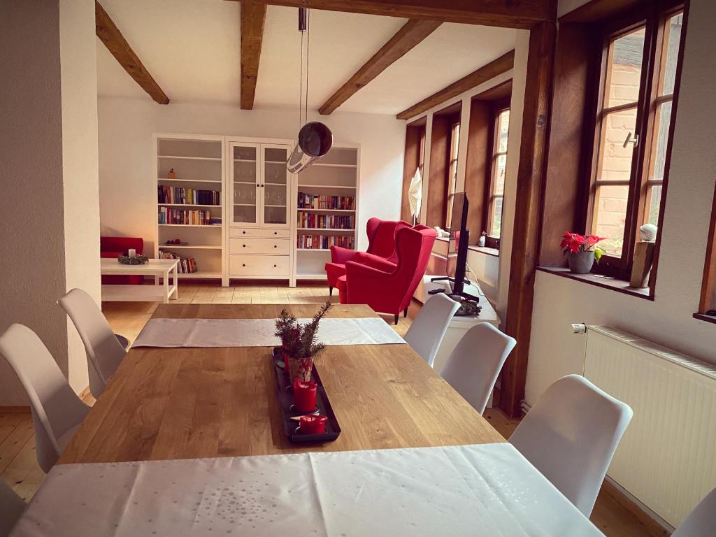 a dining room with a table and white chairs at Stieg 1 in Quedlinburg