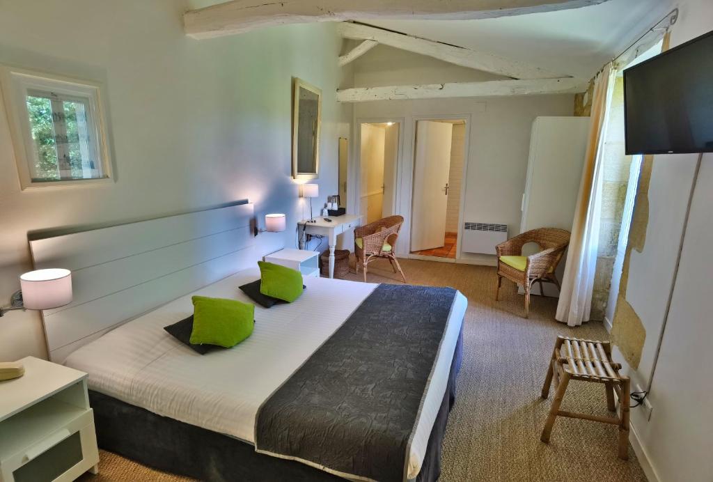 a bedroom with a large bed with green pillows at Hotel La Maison des Peyrat in Sarlat-la-Canéda