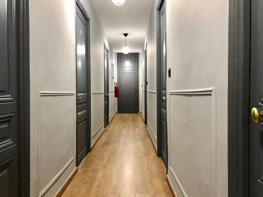 a hallway with black and white doors and a wooden floor at Open House #hostel in Nice