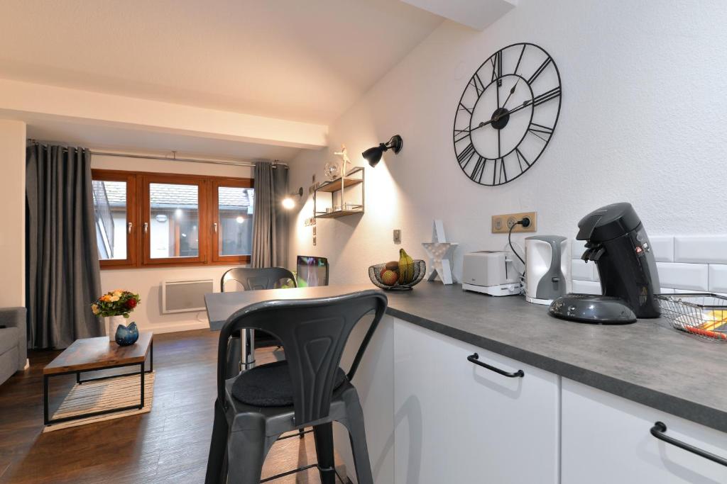 a kitchen with a counter top with a clock on the wall at La Petite Terrasse du Centre in Colmar