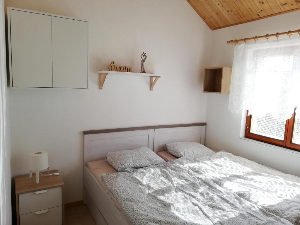 sypialnia z łóżkiem, komodą i oknem w obiekcie Apartmán s vinným sklepem Four Grapes w mieście Jevišovka