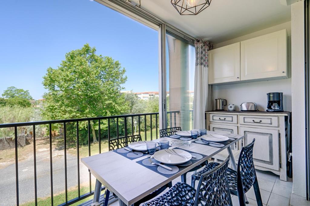 d'un balcon et d'une salle à manger avec une table et des chaises. dans l'établissement appartement T2 climatisé avec piscine secteur richelieu, au Cap d'Agde