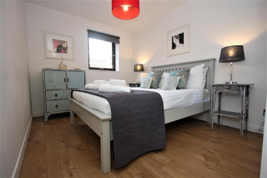 a bedroom with a large white bed and a window at Bijou Merchant City Apartment with Parking (Albion 1) in Glasgow