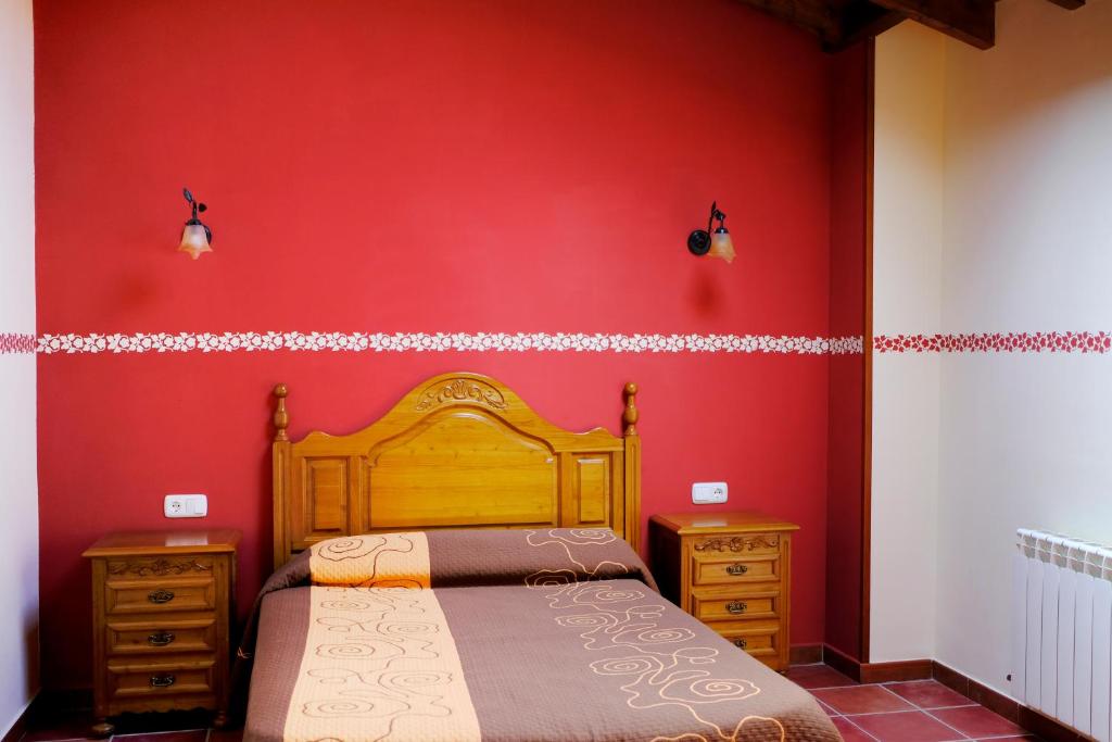 ポオ・デ・リャネスにあるCasa El Pilpayuの赤い壁のベッドルーム1室(ベッド1台、ドレッサー2台付)