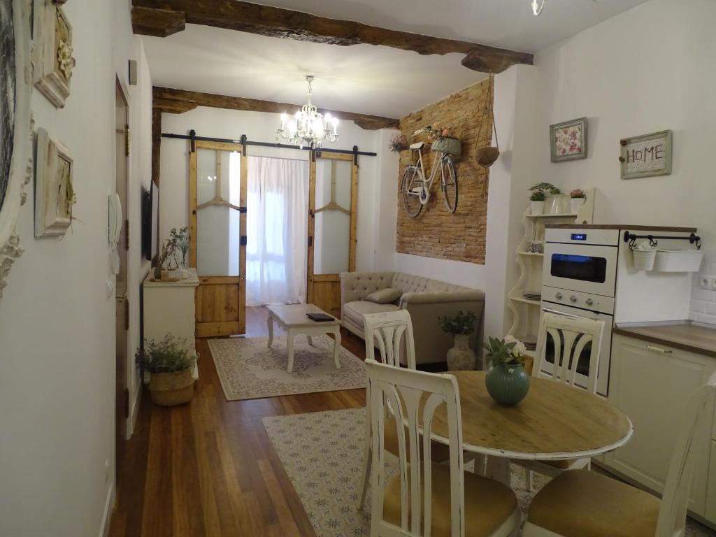 a kitchen and living room with a table and a couch at Apartament El Patio del Museo in Bilbao