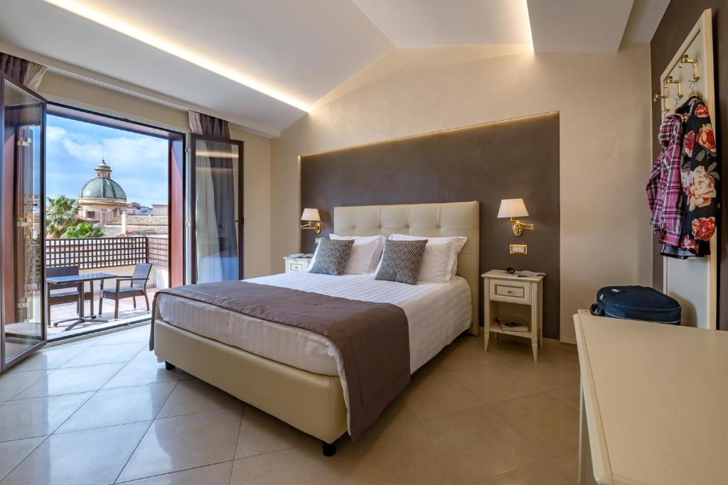 a bedroom with a large bed and a balcony at Vittorio Emanuele Boutique Hotel in Sciacca
