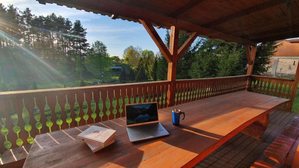 einen Laptop auf einem Holztisch auf einer Veranda in der Unterkunft Słoneczna Dolina nad Biebrzą in Goniądz