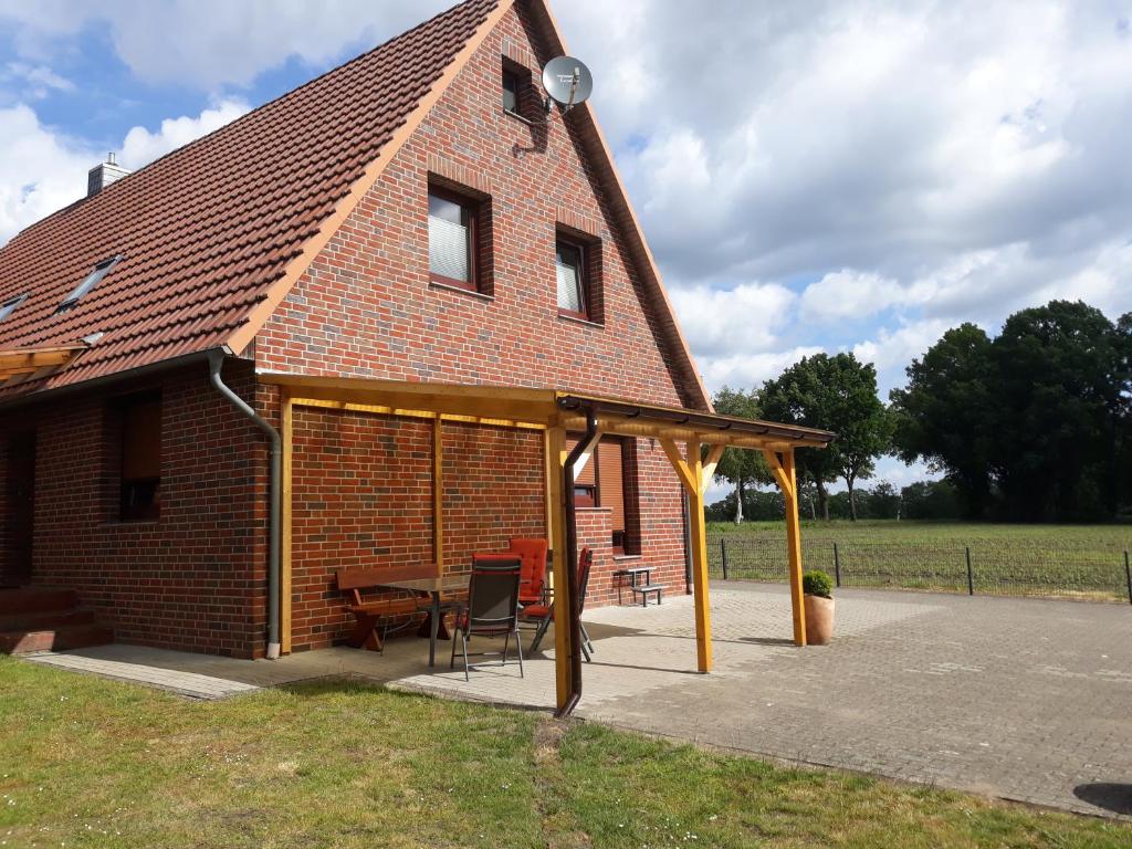 een paviljoen met een tafel en stoelen voor een huis bij Gästewohnung von Oesen in Osterholz-Scharmbeck