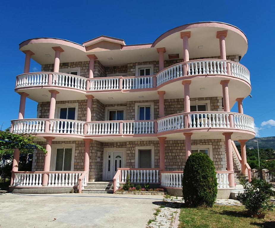 een groot roze gebouw met balkons erop bij kurt apartaments in Ulcinj