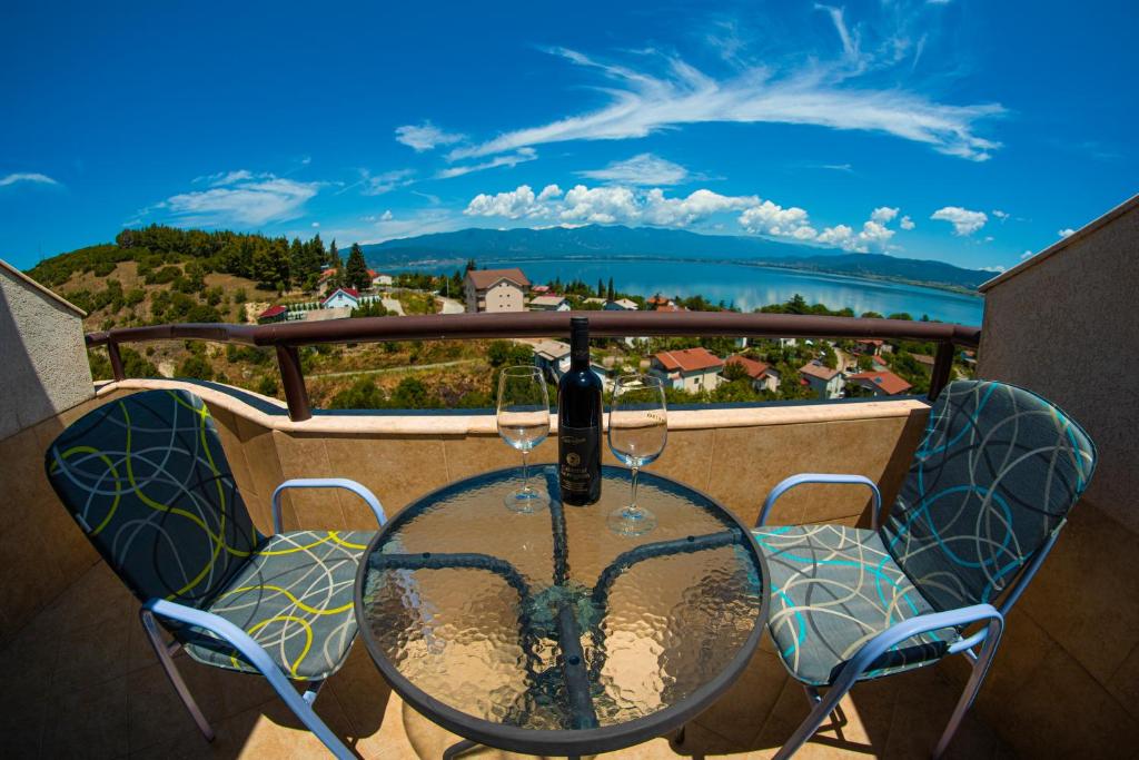 una mesa y sillas en un balcón con vistas en Villa Marija - Izgrev, en Star Dojran