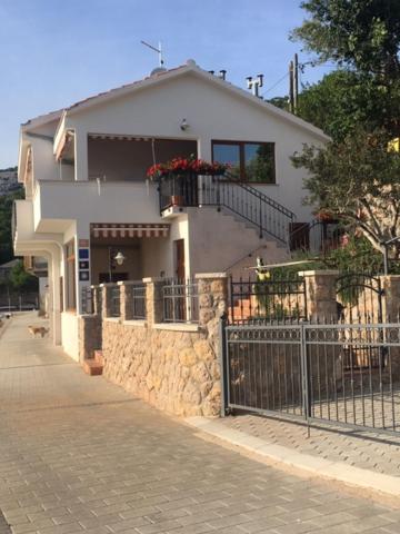 uma casa branca com uma cerca à frente. em Silva em Barić Draga