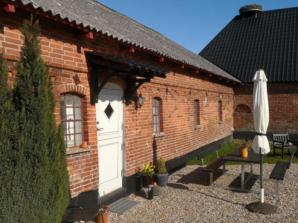 a red brick building with a white door at Karensdal B & B in Uldum