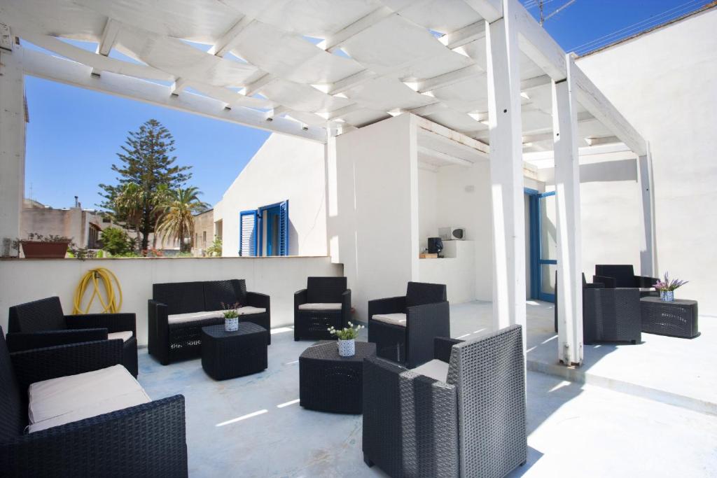 an outdoor patio with black chairs and tables at Blusanvito in San Vito lo Capo