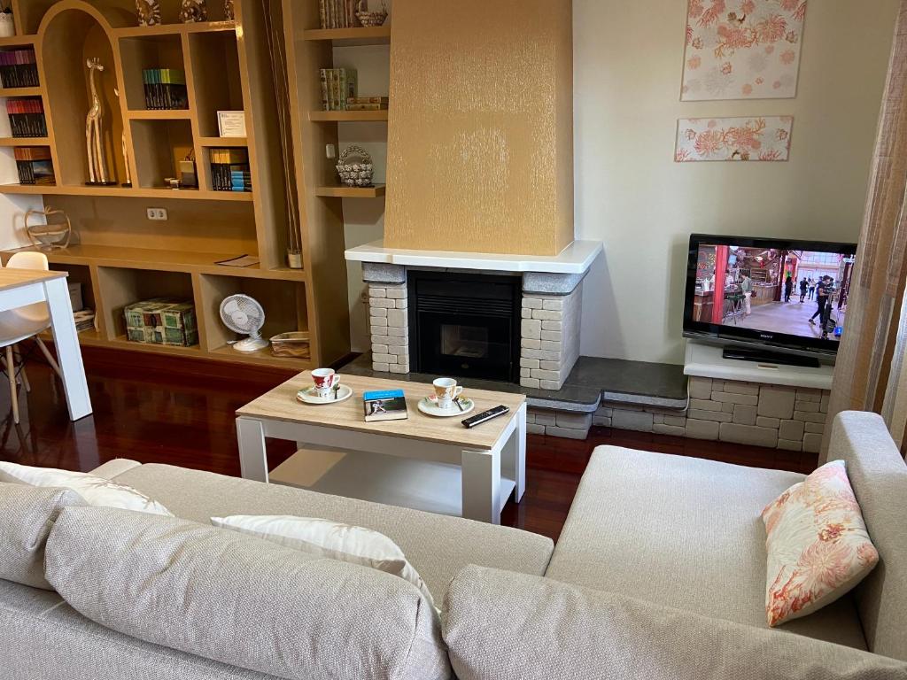 a living room with a couch and a tv at Casa Cordieira in Combarro