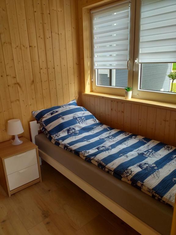 łóżko w pokoju z oknem w obiekcie Domki Letniskowe Verona we Władysławowie