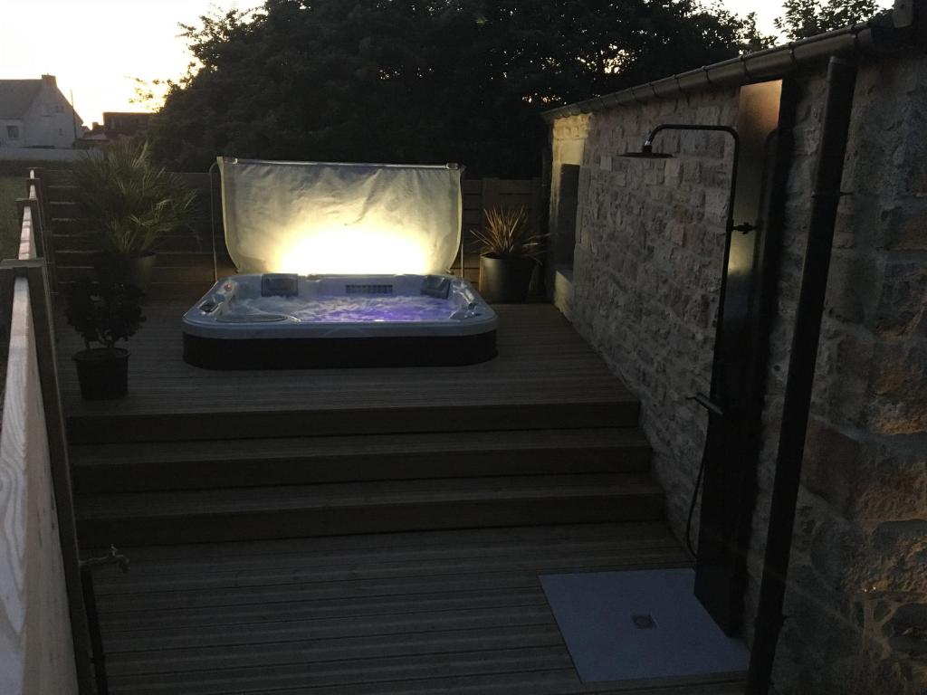 un bain à remous assis sur une terrasse la nuit dans l'établissement Gîte de Ty Nevez, Bretagne (Santec) spa, 300 m de la plage., à Santec