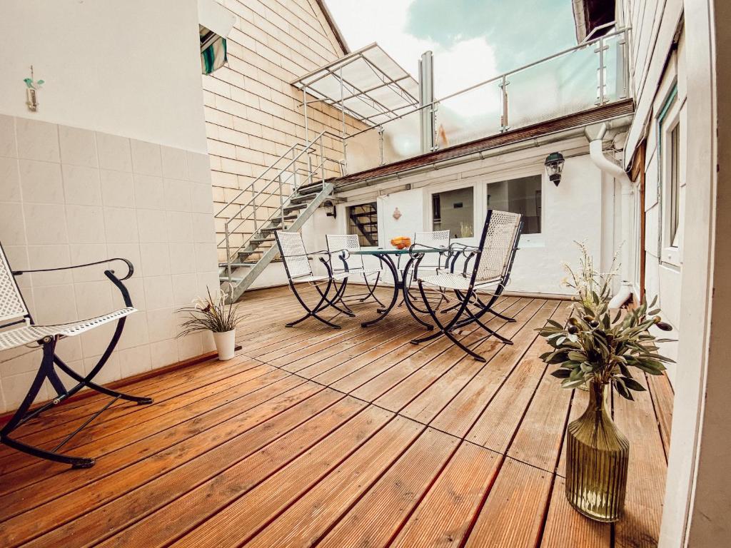 a balcony with a table and chairs on a wooden floor at Drei Linden Herzog in Wolfenbüttel