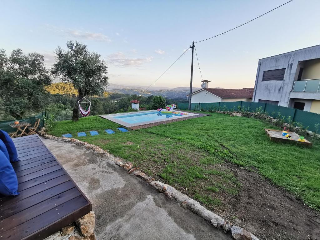 a yard with a bench and a swimming pool at Casa Mendes Lopes in Celorico de Basto