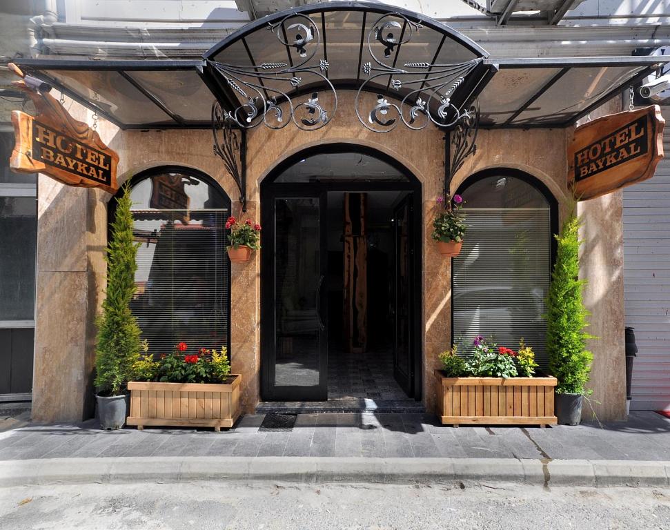 une porte d'entrée d'un bâtiment avec des fleurs et des plantes dans l'établissement Hotel Baykal, à Istanbul