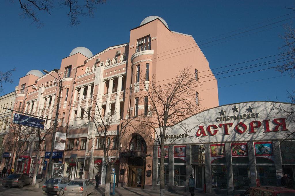 un gran edificio en una calle de la ciudad con una tienda en Astoria Hotel, en Dnipro