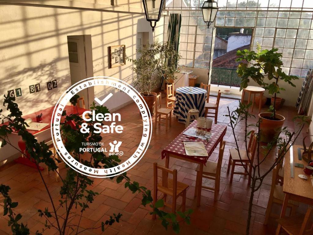 a restaurant with tables and chairs and a sign that reads clean and safe at Residencial Avenida Hostel in Tomar