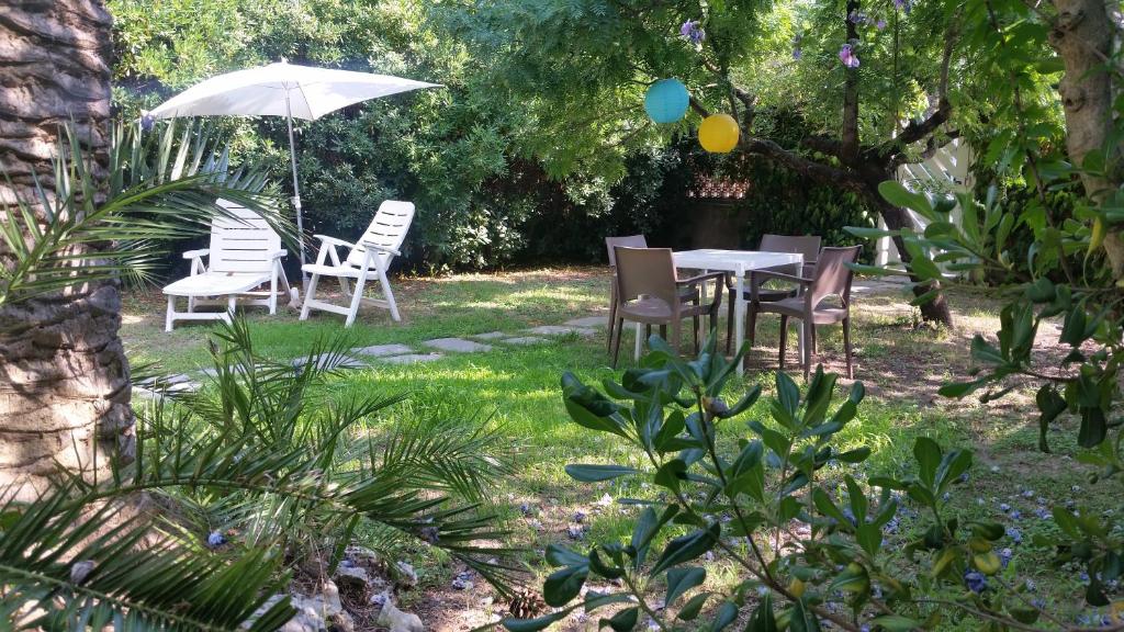 una mesa, sillas y una sombrilla en un patio en Villa sul mare, en Francavilla al Mare