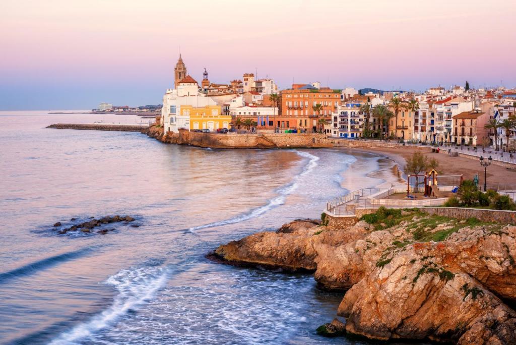 a view of a beach with buildings and the ocean at Apartamento con Licencia en Sitges in Sitges