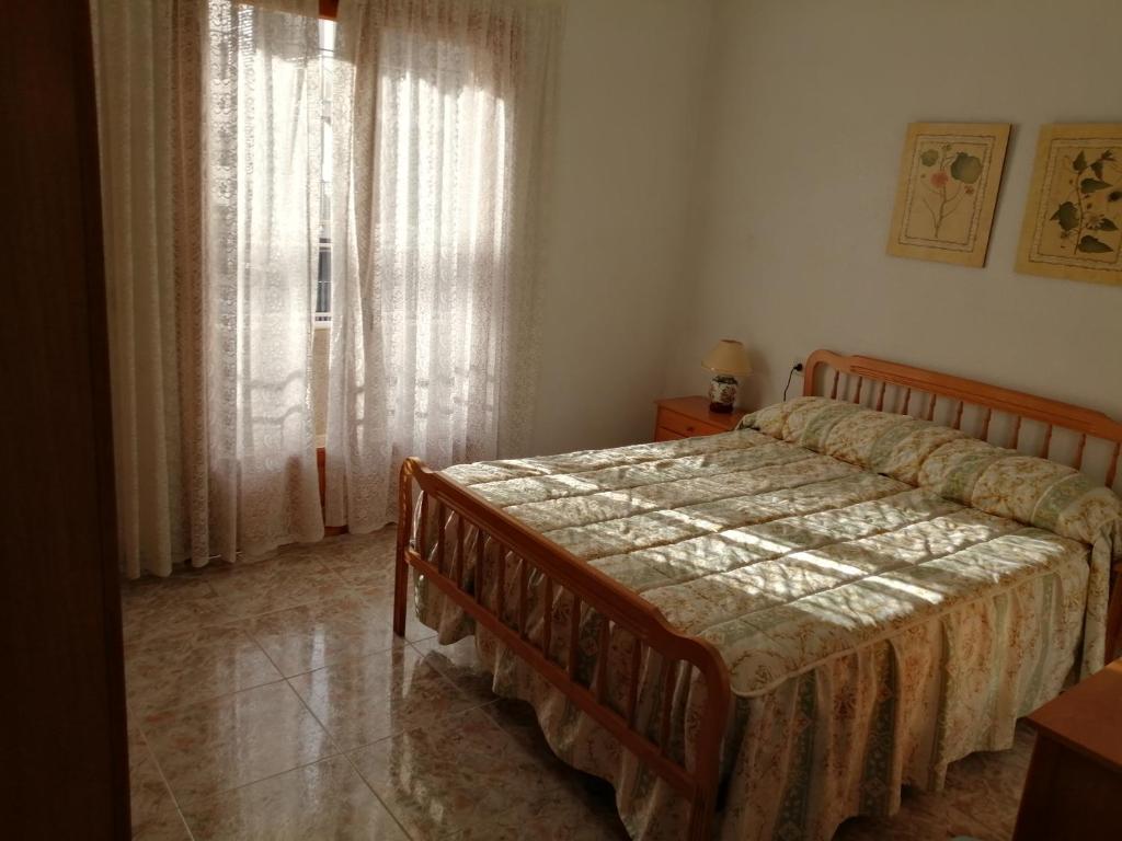 un dormitorio con una cama y una ventana en Bungalow Catral 20 en Santa Pola, en Santa Pola