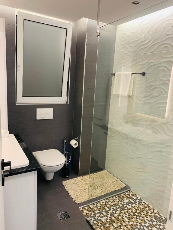 W łazience znajduje się toaleta i przeszklony prysznic. w obiekcie Apartment Marla w mieście Rodos