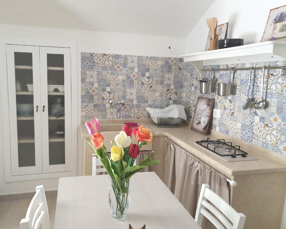 una cucina con tavolo e vaso di fiori di AP Apartment - Spiaggia della Purità a Gallipoli