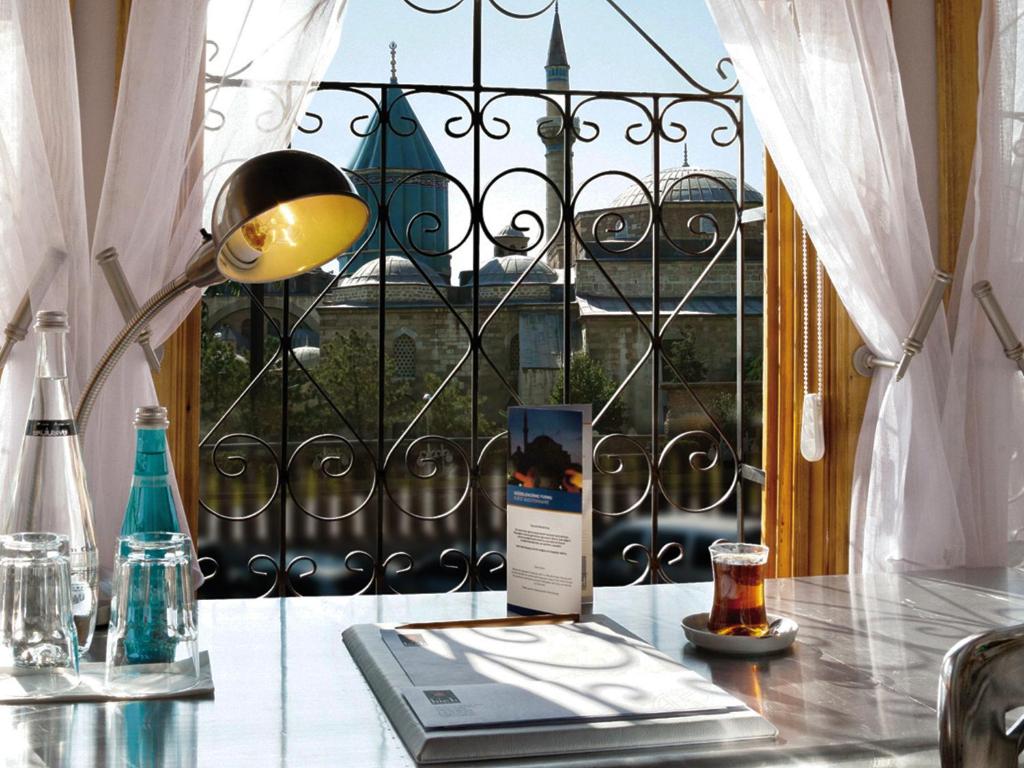 科尼亞的住宿－科尼亞高酒店，一张桌子,上面有台灯和一本书