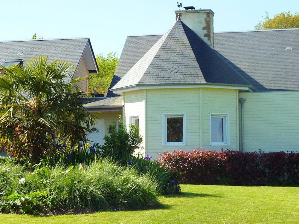 a house with a palm tree in a yard at Chambre d'Hotes La Queue au Loup in Le Molay-Littry