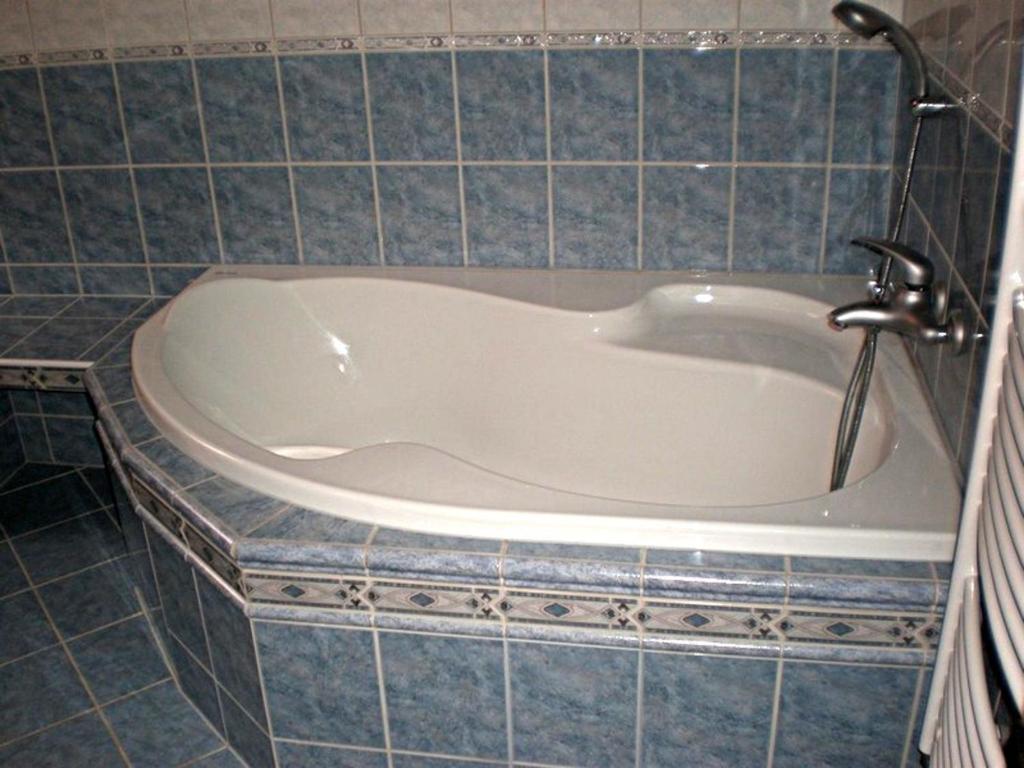 W łazience z niebieskimi kafelkami znajduje się wanna. w obiekcie Penzion "Apartmány U Semušky" w mieście Pernink