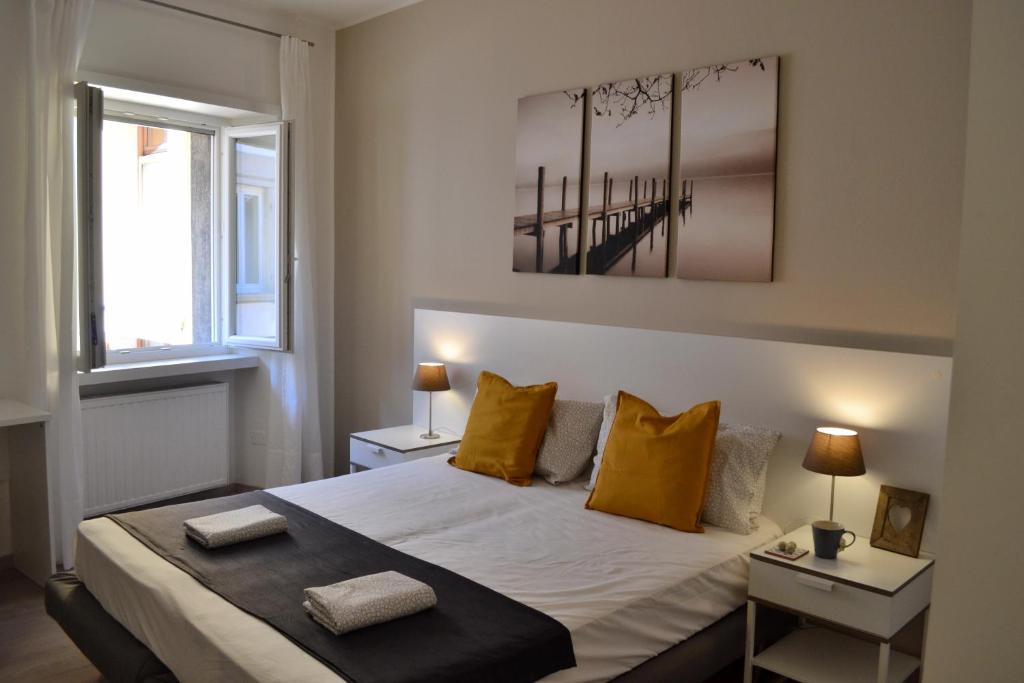una camera da letto con un grande letto con cuscini gialli di Blue Nest Apartment a Torbole