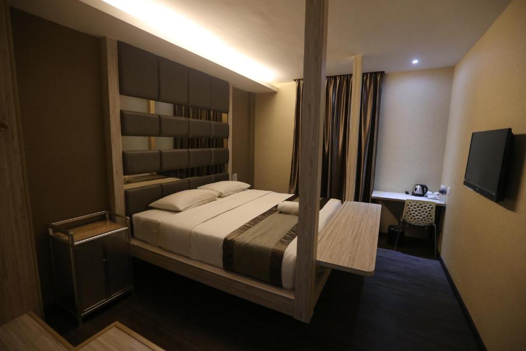 a bedroom with a large bed and a television at Kota Heritage Hotel in Kota Tinggi