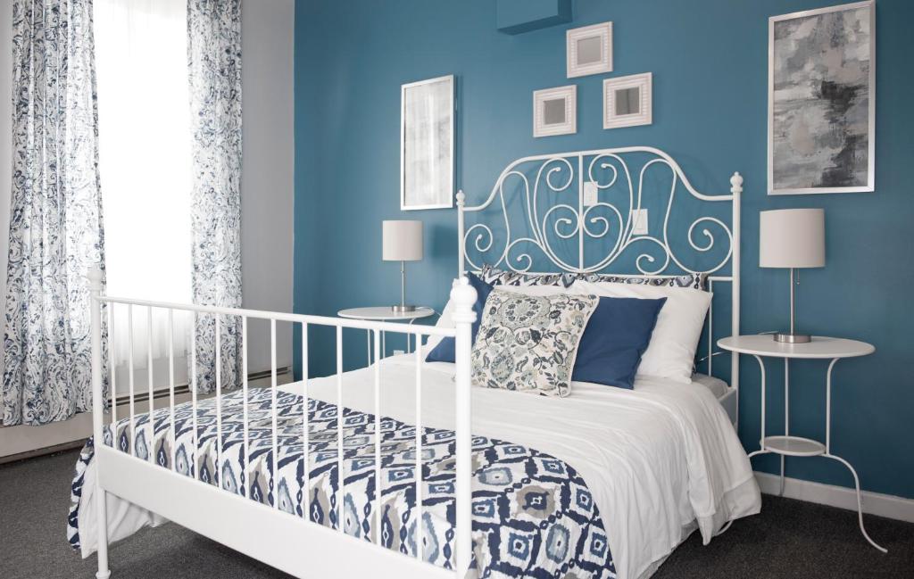 1 dormitorio con 1 cama blanca y paredes azules en Dream Catcher Travel House en Toronto
