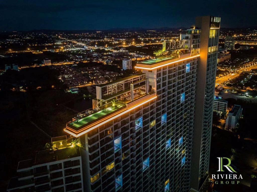 un grand bâtiment avec des lumières au-dessus de celui-ci la nuit dans l'établissement Riviera Jomtien by Zoom Pattaya 1, à Jomtien Beach