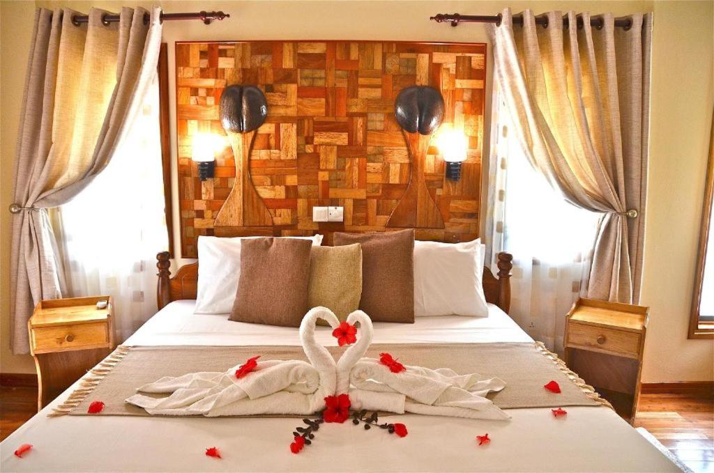 a bedroom with two swans in towels on a bed at Calou Guest House in La Digue