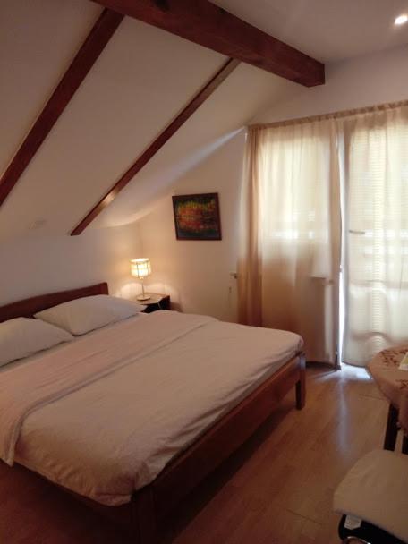 a bedroom with a large bed and a window at Guesthouse Marton in Jezerce