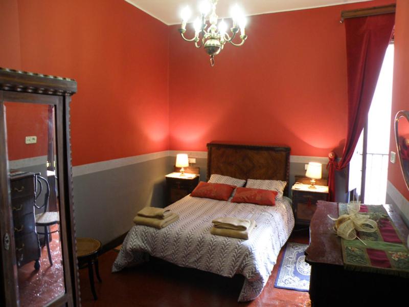 1 dormitorio con 1 cama con paredes rojas y espejo en Casa Rural Ulibarri, en Allo