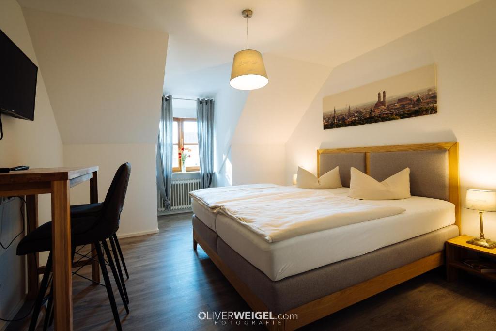 um quarto com uma cama e uma secretária. em Hotel Reiter Bräu em Wartenberg