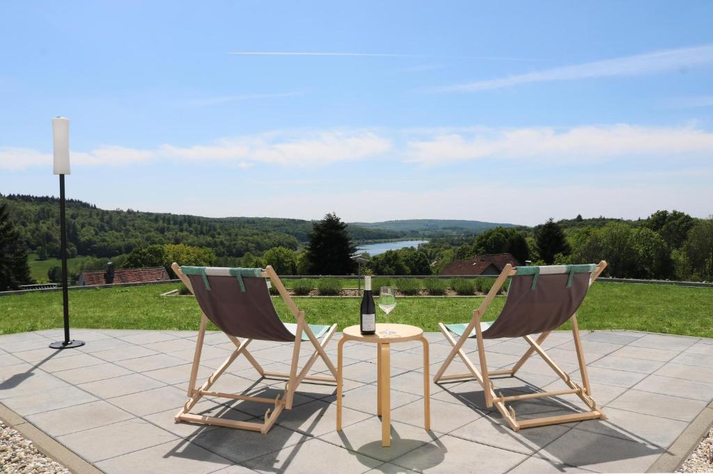 twee stoelen en een tafel met een fles wijn bij Lessing31 in Schotten