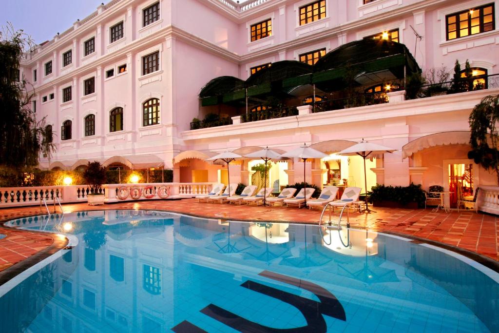 a large swimming pool in front of a building at Saigon Morin Hotel in Hue