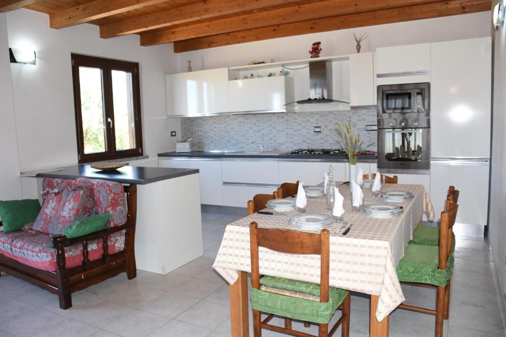 a kitchen and dining room with a table and chairs at Su Cuile relax house with barbecue in Martis