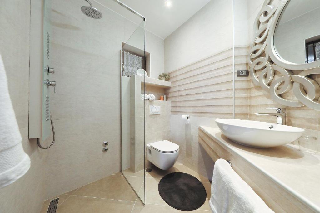 a bathroom with a sink and a toilet and a shower at Villa Dalmatino in Pakoštane