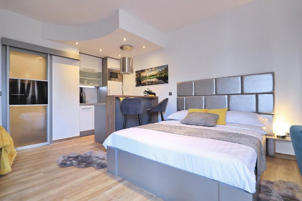 a bedroom with a large bed and a kitchen at Villa Dalmatino in Pakoštane