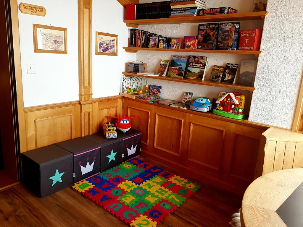 リギ・カルトバートにあるホテル レストラン アルピナの床に敷かれた絨毯と本棚のある部屋